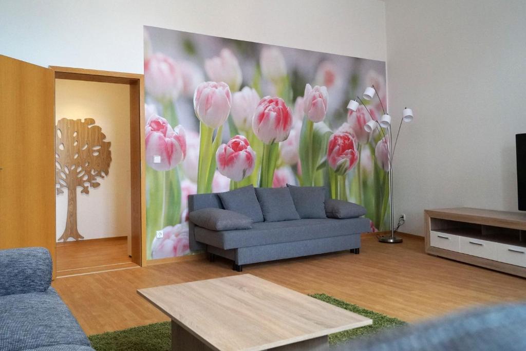 a living room with a painting of pink tulips at GUWO Gästewohnung Straupitzstraße 12 in Guben