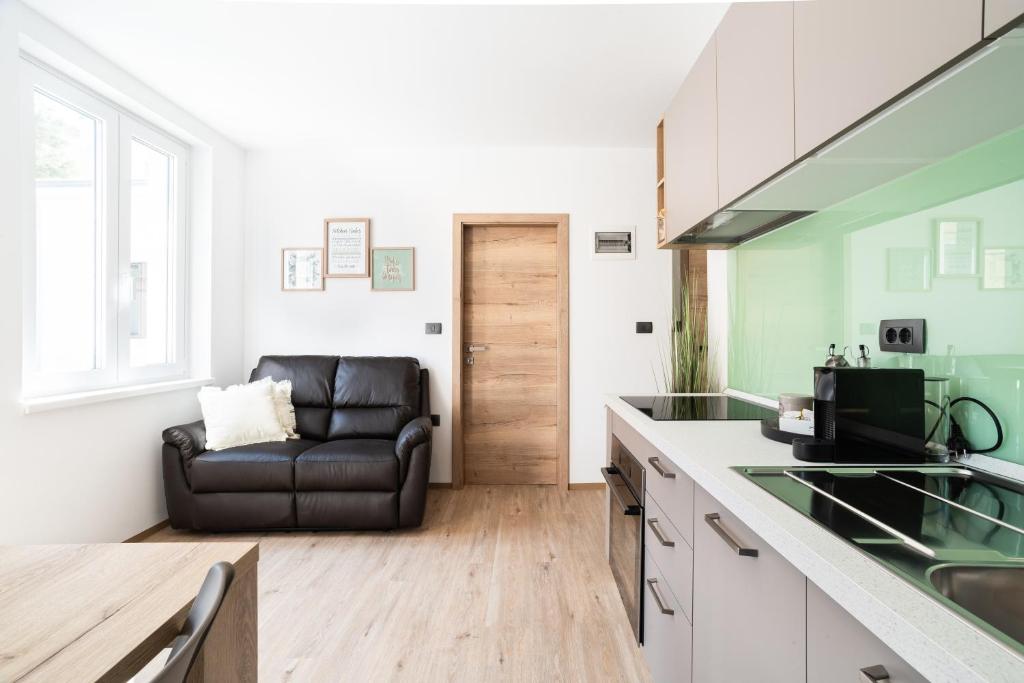 eine Küche mit einem schwarzen Ledersofa in einem Zimmer in der Unterkunft CAPRARIA appartments in historic center, with private parking in Koper
