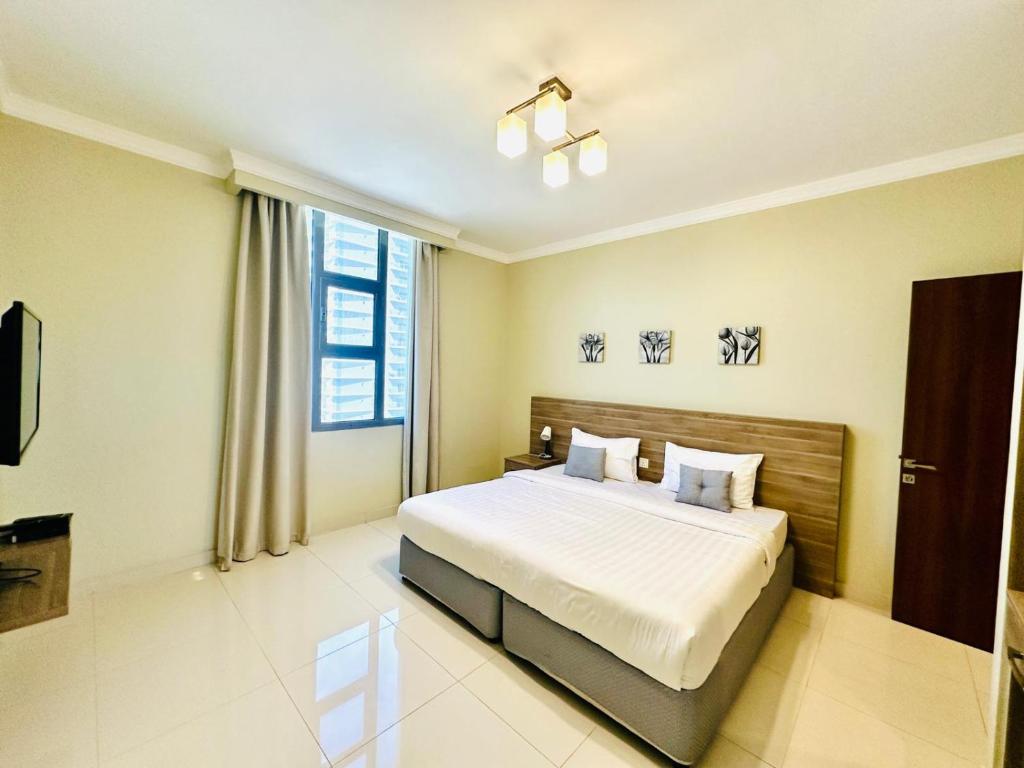 Un dormitorio con una cama y una ventana grande. en HAVEN TOWER, en Juffair