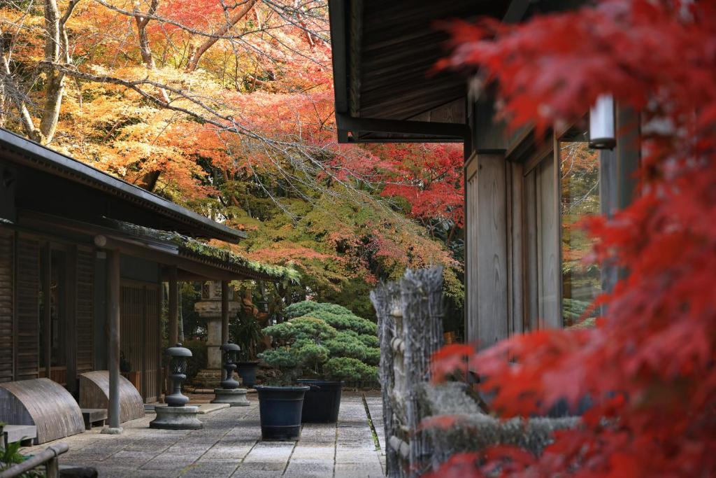 a walkway with red leaves on trees and a building at Oukai Villa Izumi in Izumi