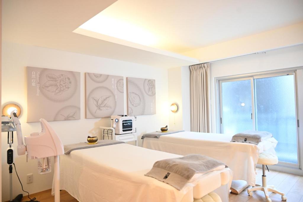 a hospital room with two beds and a window at Yolo Hotel in Tokyo