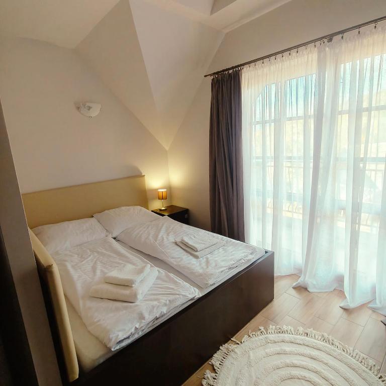 a bedroom with a bed and a large window at Gościniec Tenczyn in Tenczyn
