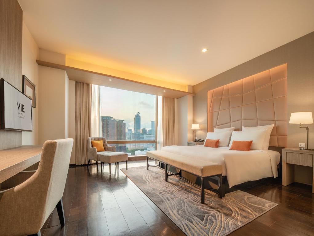A king room with a work desk, lounge chair, television, and city view.