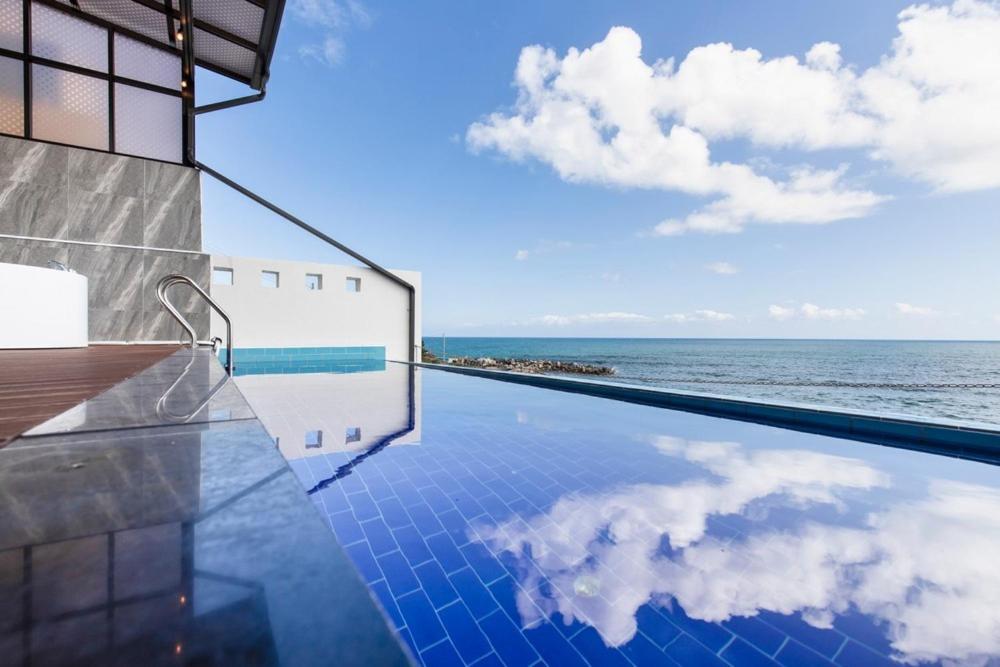a swimming pool with a view of the ocean at Yeongdeok Searest Pool Villa in Changsa-ri