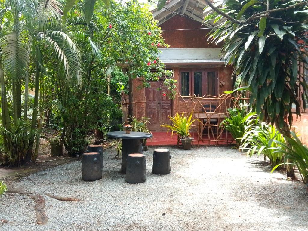 a patio with a table and some trees and a house at My House Ahangama in Ahangama
