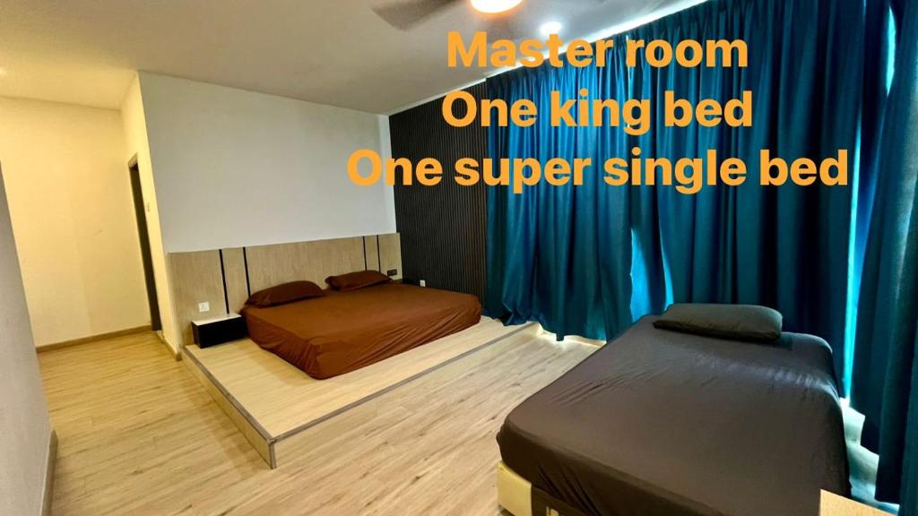 a bedroom with two beds and a blue curtain at LC Paragon Apartment in Labuan