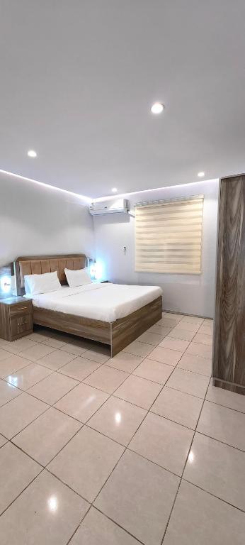 a bedroom with a bed and a tiled floor at قمة قباءلشقق المفروشه in Al Madinah