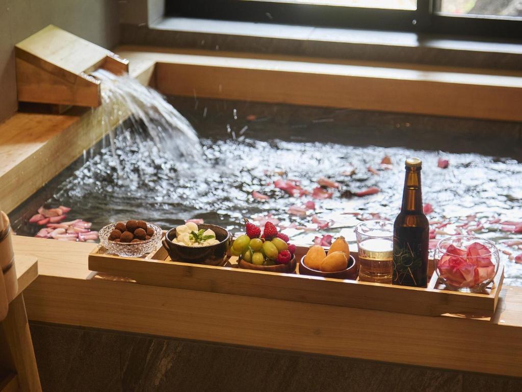 un étang à poissons avec de la nourriture et une bouteille de bière dans l'établissement Hakone Retreat villa 1/f, à Hakone 111 autres photos