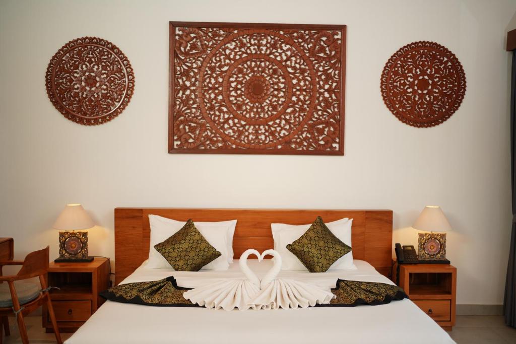 ein Schlafzimmer mit einem Bett mit zwei Ringen darauf in der Unterkunft Dewi Kunti Villa in Tegalalang