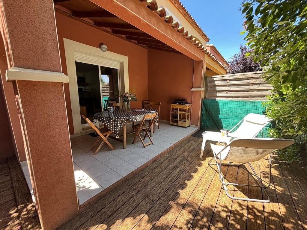 a patio with a table and chairs on a house at Le Cersois,proche Canal du Midi et de la Mer, environnement paisible et parking privé in Cers