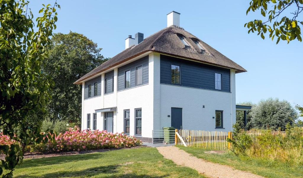 an old white house with a gambrel roof at Polderhuys Goede Hope in Hoofdplaat