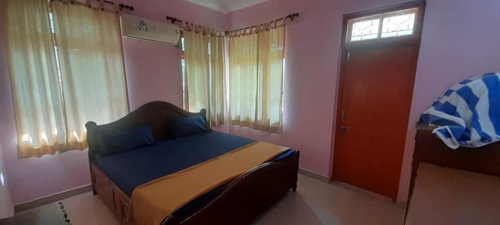 a bedroom with a bed and a window and a door at G shepherd Villas And Apartments in Colva