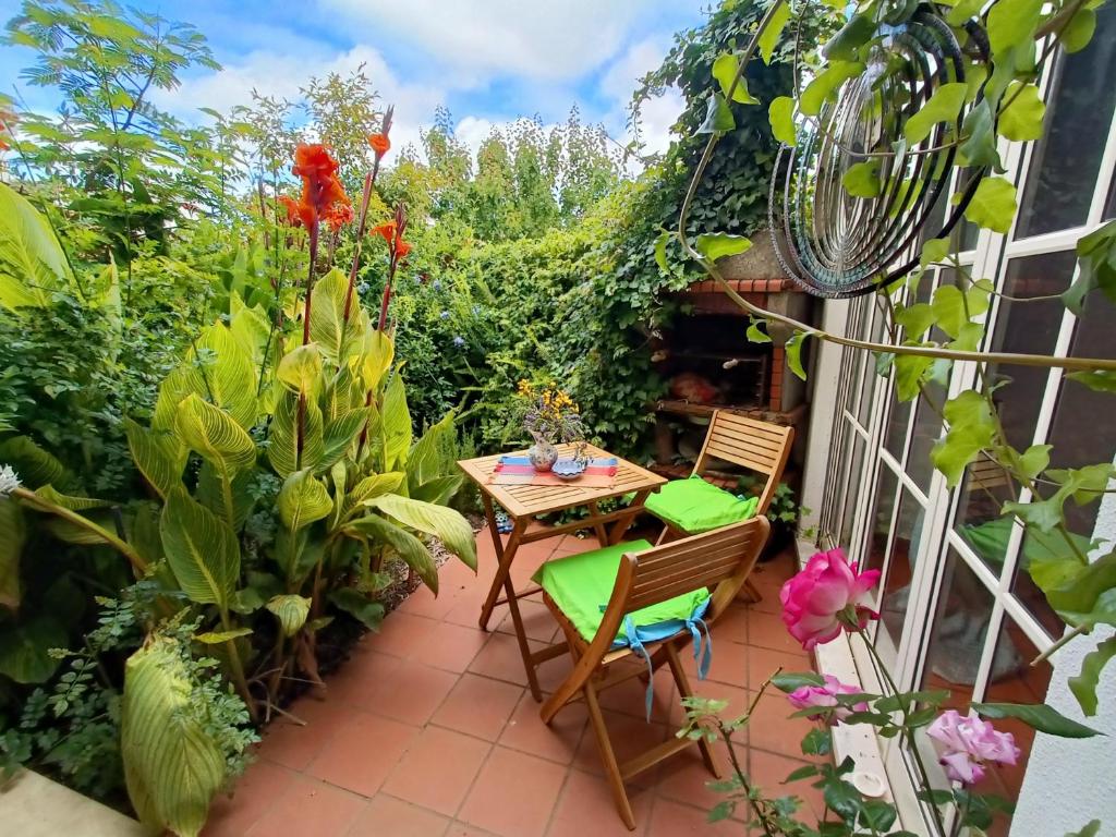 a patio with a table and chairs and plants at Casa Flow and Glow in Santiago do Cacém