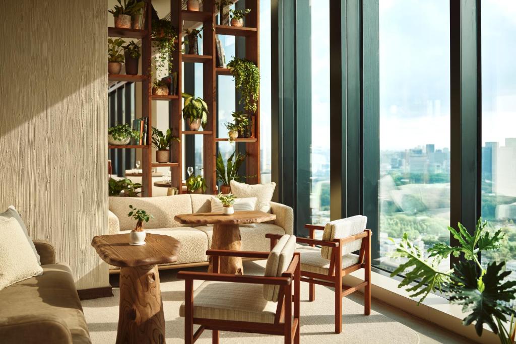 a living room with tables and chairs and windows at 1 Hotel Tokyo in Tokyo