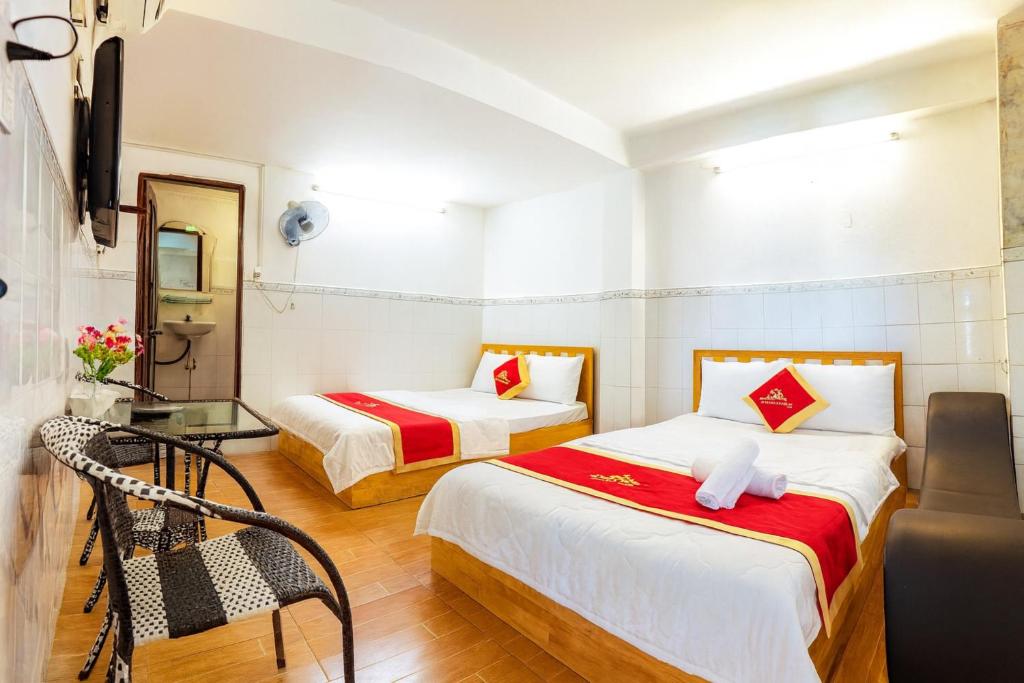 Habitación con 2 camas y mesa de cristal. en Trung Bảo Hotel, en Ho Chi Minh