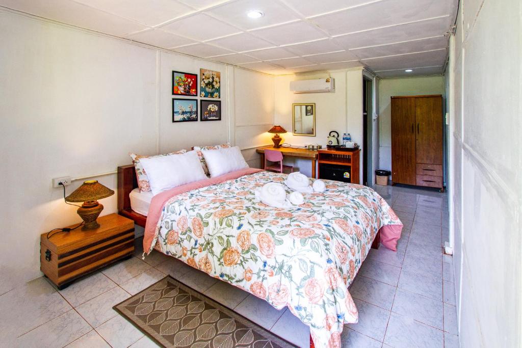Ko Lanta YaiにあるLe Panpurie Koh Lanta Resortのベッドと机が置かれた寝室