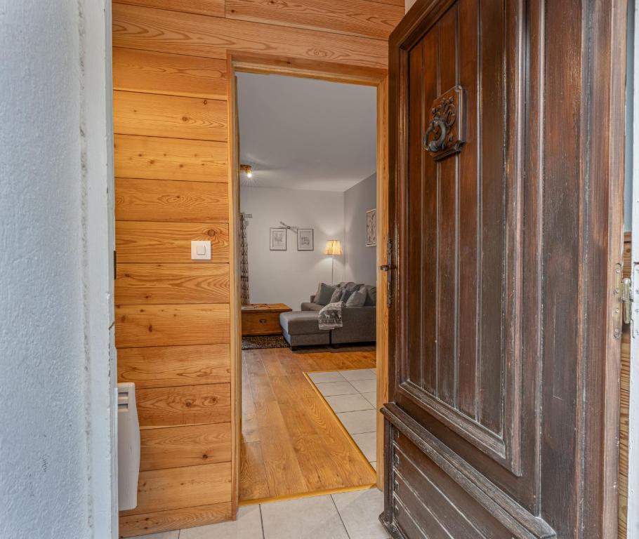 a wooden door leading into a living room at Près des Forts in Briançon
