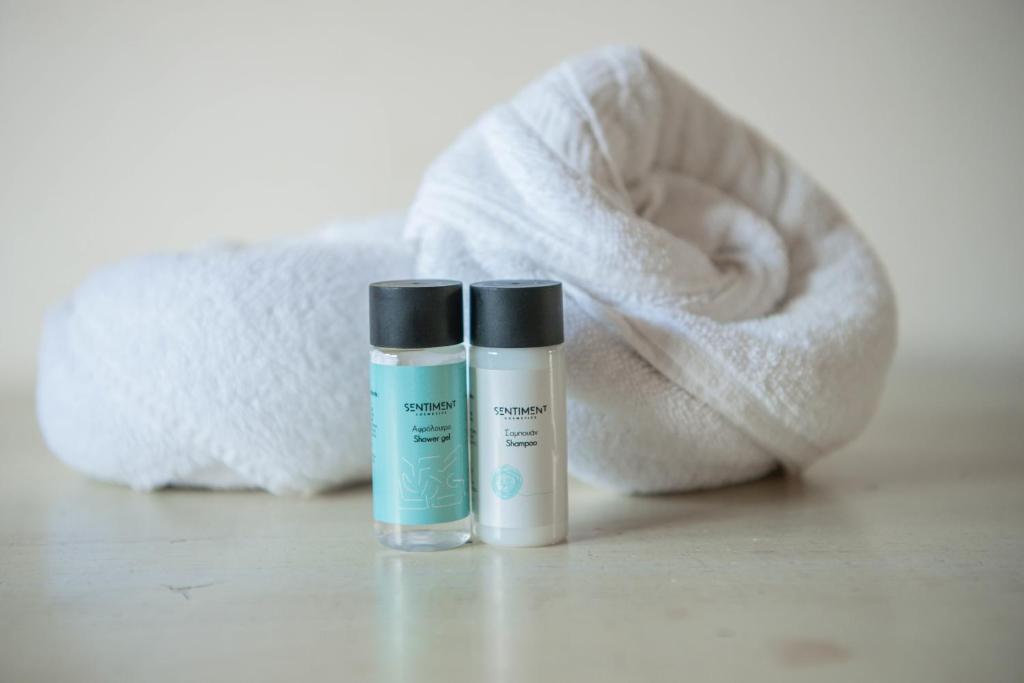 two bottles of moisturizers sitting next to a towel at Bluewave Apartment in Pyla
