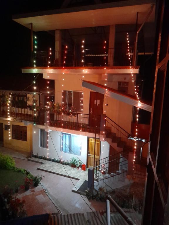 a building with a balcony with lights on it at night at Bethel homestay Delo in Kalimpong