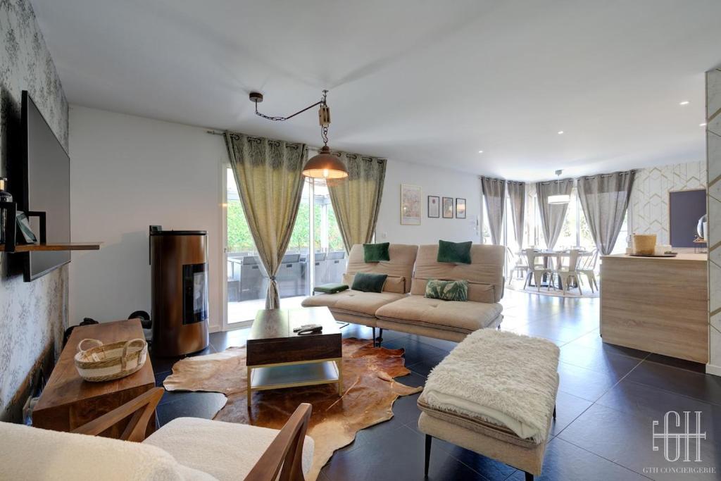 ein Wohnzimmer mit Sofa und Tisch in der Unterkunft La Familial - 6V - Parking - Jardin - Bureau in Montbazon