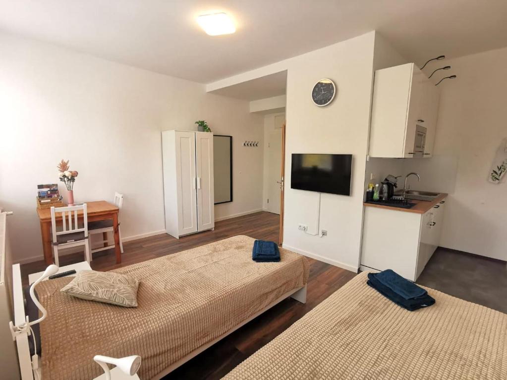 a room with two beds and a table and a kitchen at Appartement direkt am Fluss Nähe Zentrum in Coburg