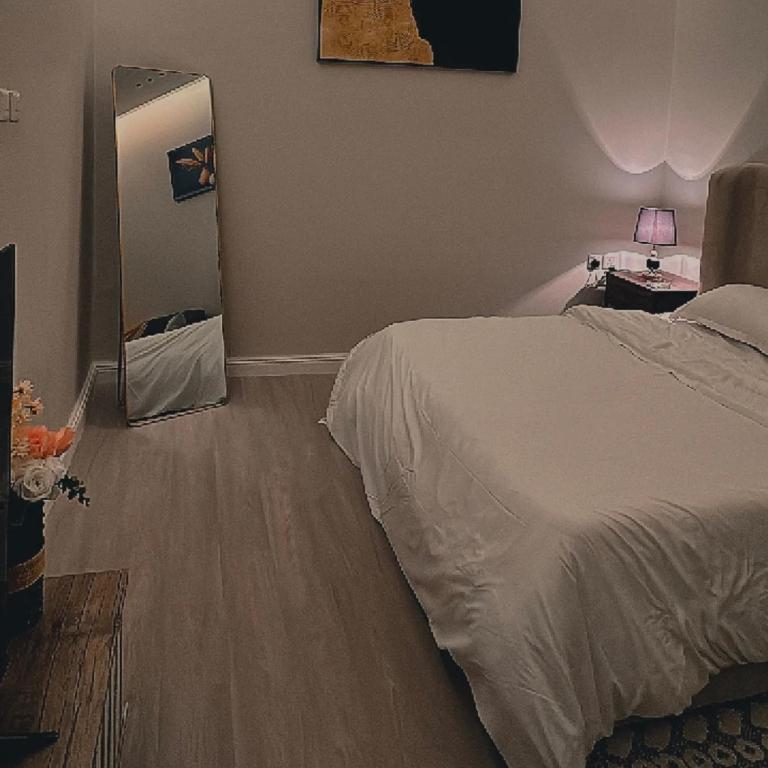 a bedroom with a white bed and a mirror at الزعفران in Amman