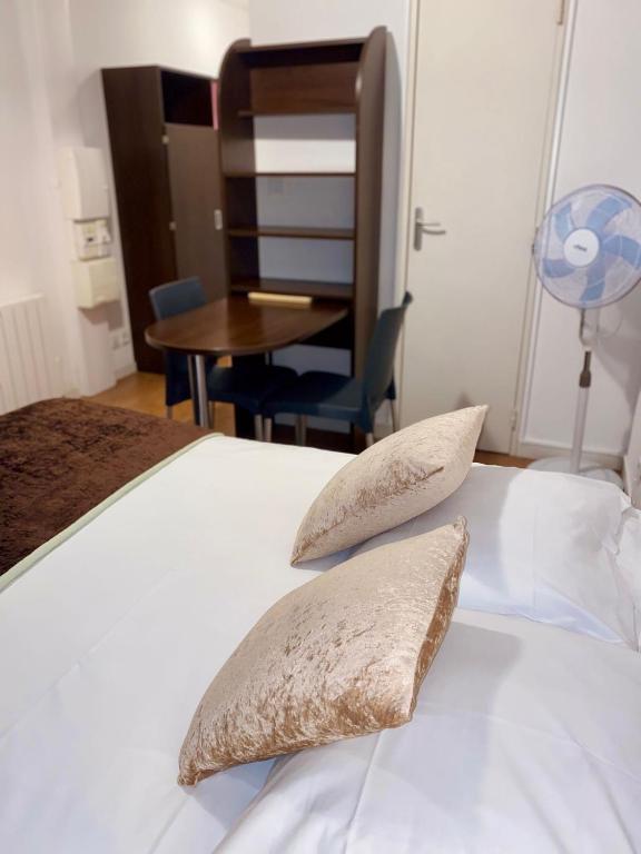 ein Schlafzimmer mit einem Bett mit zwei Kissen und einem Tisch in der Unterkunft Central Fac in Bourg-en-Bresse