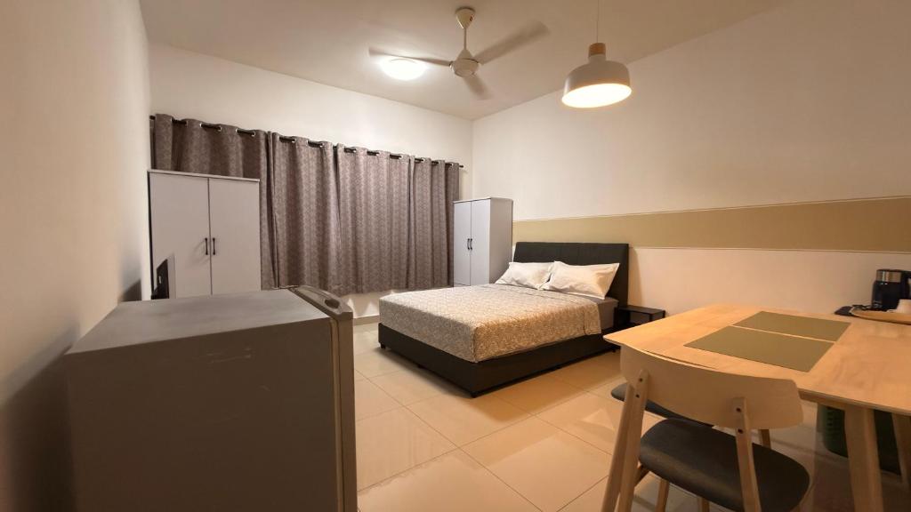 a bedroom with a bed and a desk and a table at Cozy SK 1 Room 3 Pax UPM MRT in Seri Kembangan