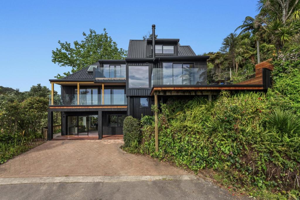 una casa en la cima de una colina con cristal en Treetop Hideaway - Ohope Holiday home, en Ohope Beach