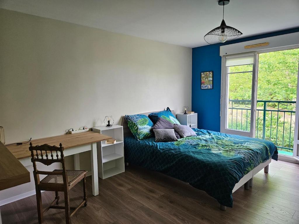 a bedroom with a bed and a desk and a table at Orleans appartement 31 m2 in Saint-Jean-de-la-Ruelle