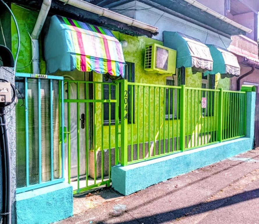 a green fence on the side of a building at Artsy fully equipped 2 bedrooms House all to yourself! in Bucharest