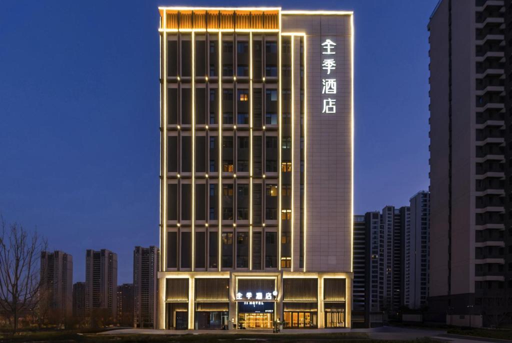 een hoog gebouw met een bord aan de zijkant bij JI Hotel Qingdao Oriental Eden in Qingdao