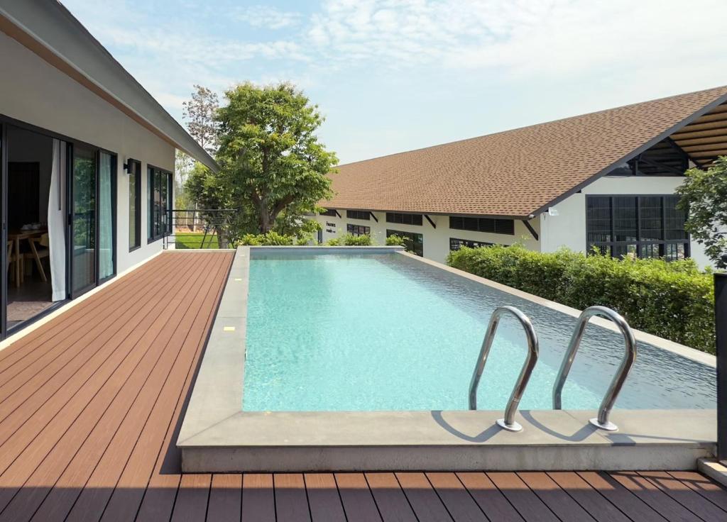 a swimming pool on a deck next to a house at PASSA ผัสสะ Tea Plantation @Mae On in Ban Huai Kaeo