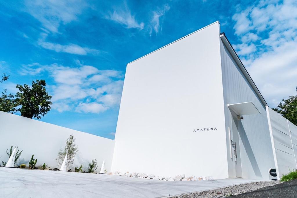 a white building with a door on the side at Amatera in Kami Amakusa