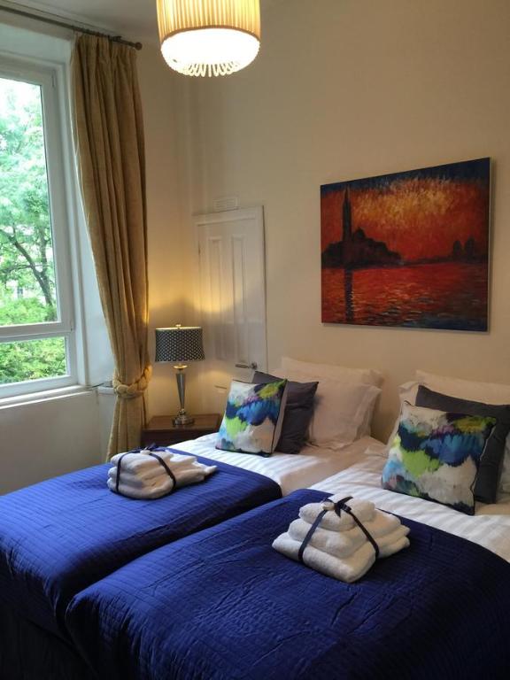 2 camas en un dormitorio con sábanas azules en Trefoil Apartment - 2 Bedrooms, en Glasgow