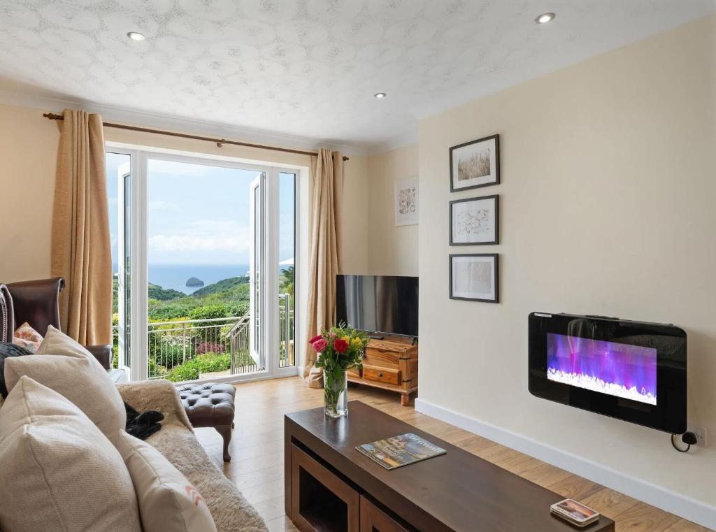 Una sala de estar con un sofá y un televisor. en Peaceful Home Sea Views Private Parking, en Treknow