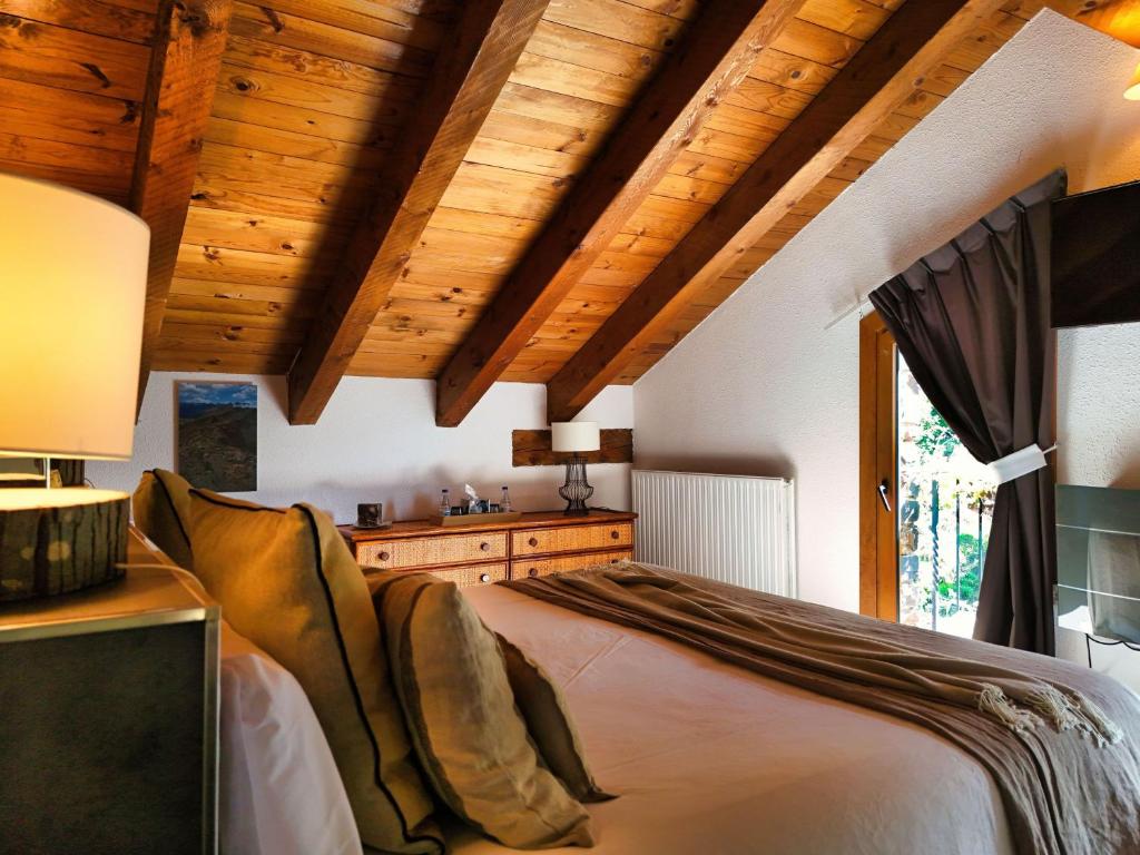 a bedroom with wooden ceilings and a large bed at B&B La Lluna in La Massana