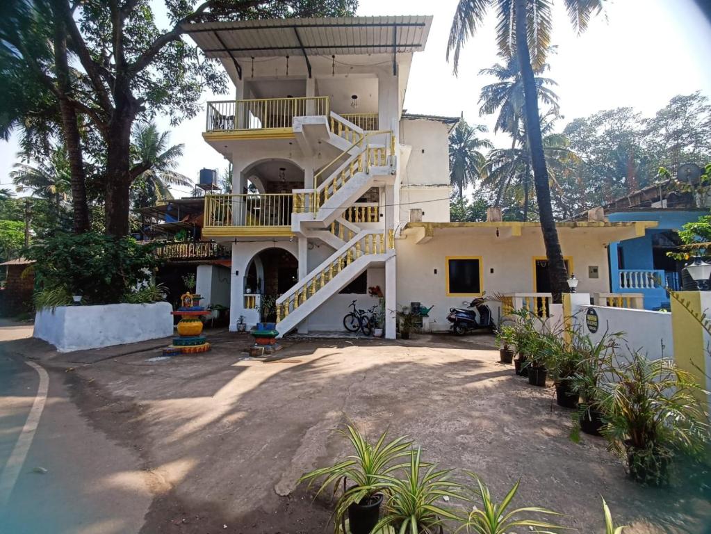 un edificio blanco con una escalera delante en Riverside, The European Homestay 1 and 2! Luxury and Value in Goa's delightful location, en Agarvado