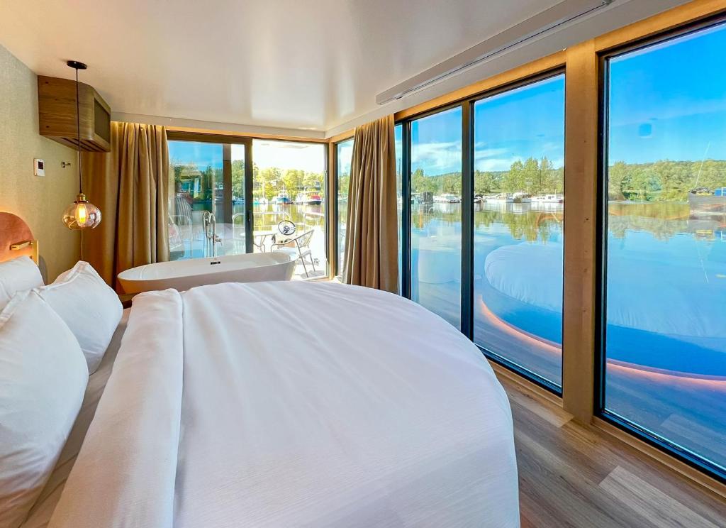 a bedroom with a large bed with a view of the water at L'Escale Royale Verneuil-sur-Seine in Verneuil-sur-Seine