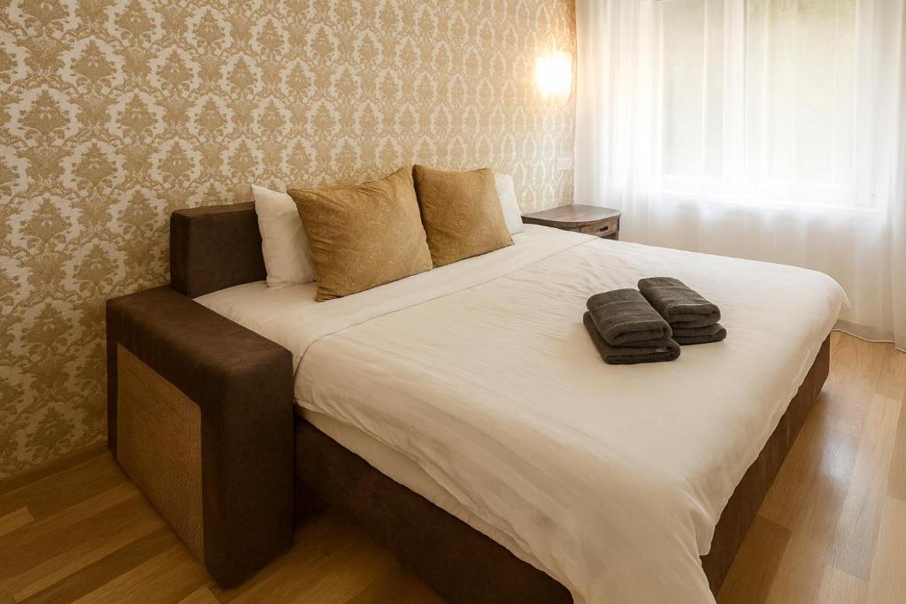 ein Schlafzimmer mit einem großen Bett mit zwei Handtüchern darauf in der Unterkunft Friendly two-room apartment in Sigulda