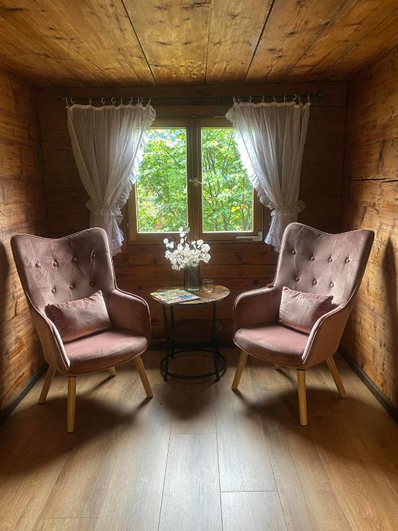 two chairs and a table in a room with a window at Haus Renard in Bartholomäberg