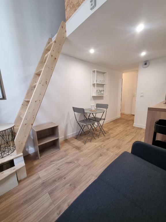 Charmant Studio en Duplex في مارسيليا: غرفة معيشة بها درج وطاولة