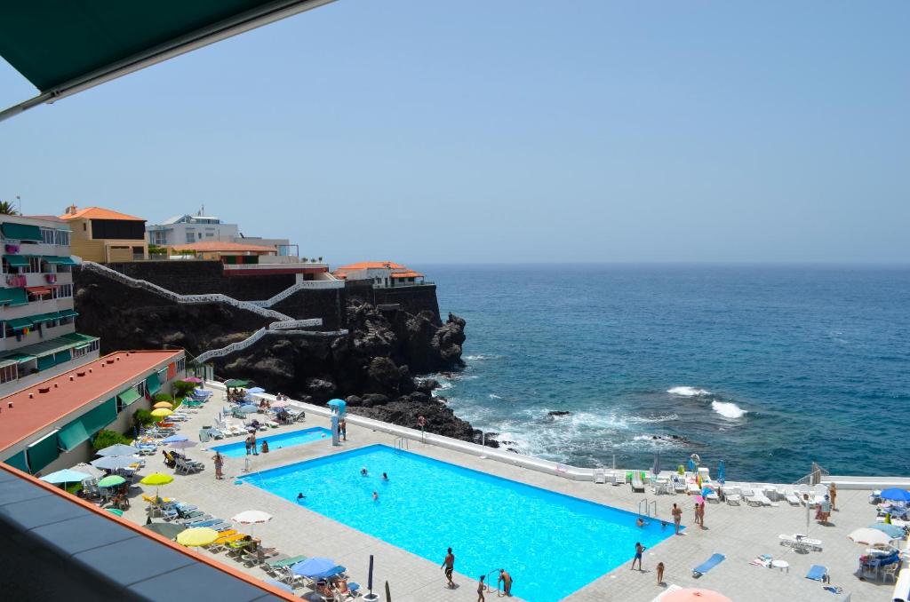 a swimming pool on the beach near the ocean at Feel the Breath of the Ocean in Puerto de Santiago