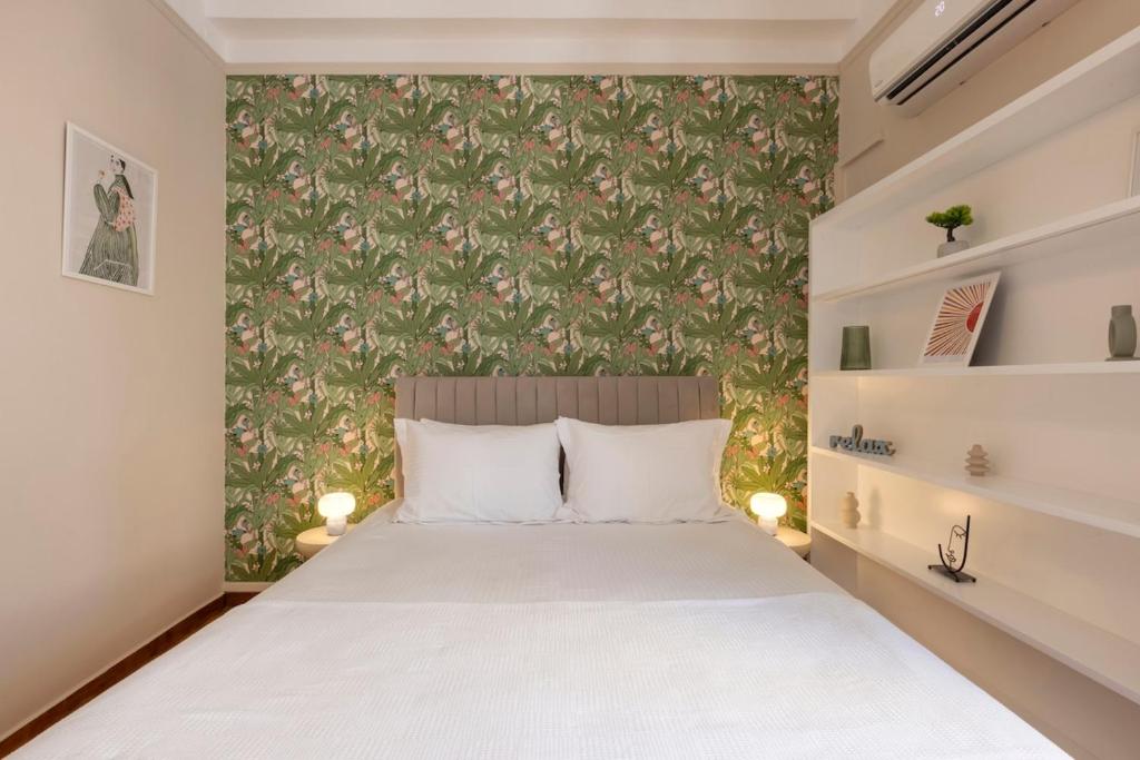 a bedroom with a white bed with a floral wallpaper at Kallirois Avenue House 7ppl 2BR Acropolis Metro Plaka 300m in Athens