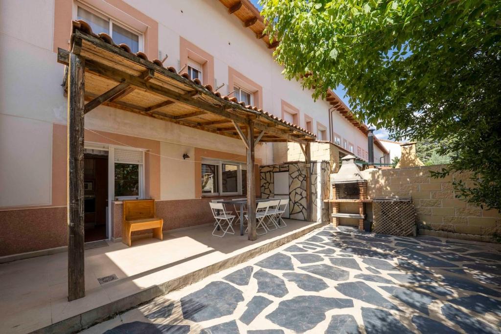 eine Terrasse eines Hauses mit einer hölzernen Pergola in der Unterkunft Bonita casa en Torrejón del Rey in Torrejón del Rey