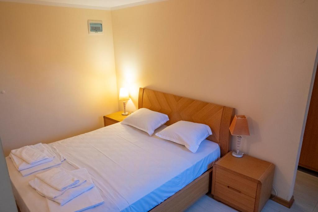 une chambre avec un lit avec des draps blancs et des oreillers dans l'établissement Borovets Snow Hotel, à Borovets