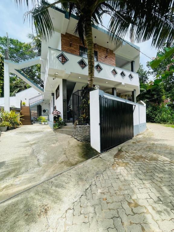 a house with a palm tree in front of it at Bosilu Villa in Weligama
