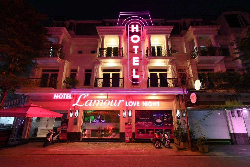 ホーチミン・シティにあるL'amour Hotelの目の前にネオンの看板が立つホテル