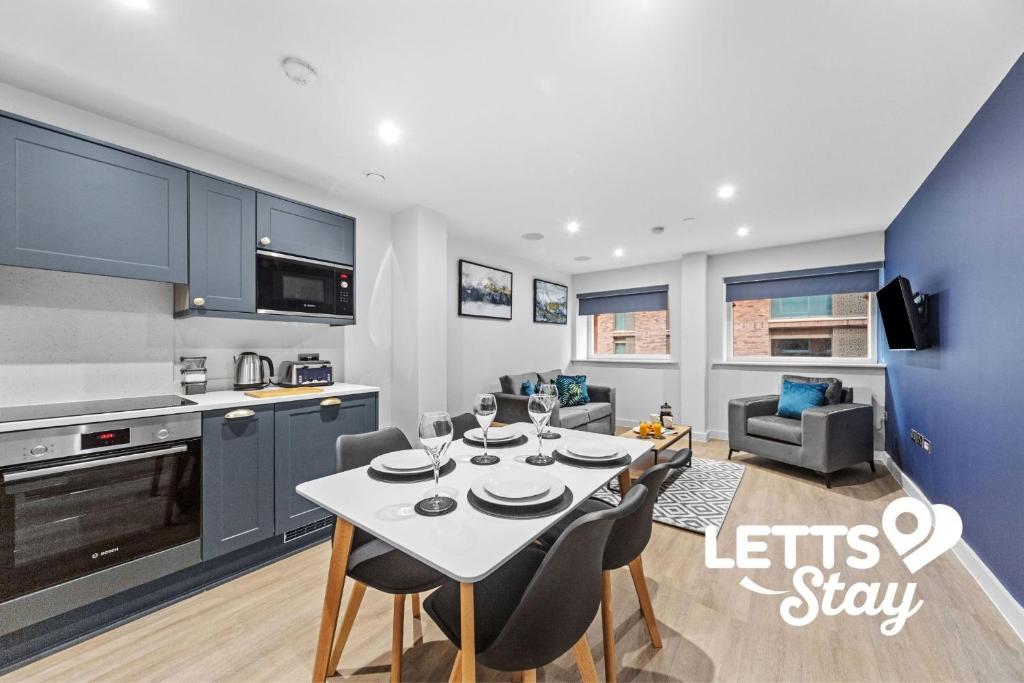 een keuken en woonkamer met een tafel en stoelen bij The Old Schoolhouse in Leeds