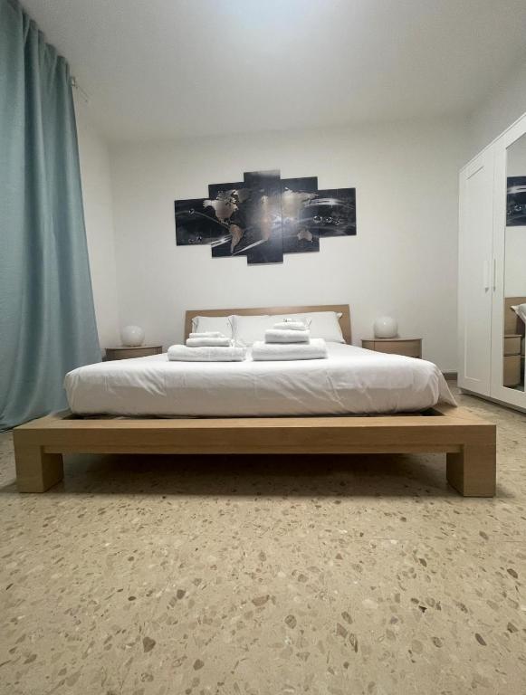 a bedroom with a large bed with two pictures on the wall at B&B IL QUADRIFOGLIO in Iesi